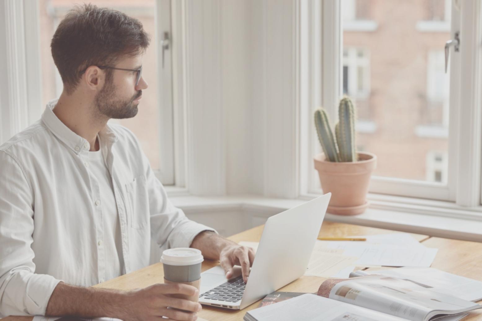 Business owner reviewing financial reports on laptop with charts and graphs displayed on screen